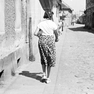 People walking down a narrow, old street.