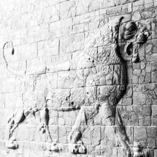 Here's a brief summary: Stone relief depicts a lion with a bull or deer.
