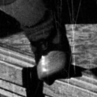 Here's a brief summary of the image: Child stands in a doorway, holding an object.