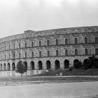 Large, curved building with arches and a tiered facade.