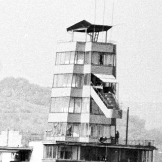 Rowing regatta with spectators and a control tower.