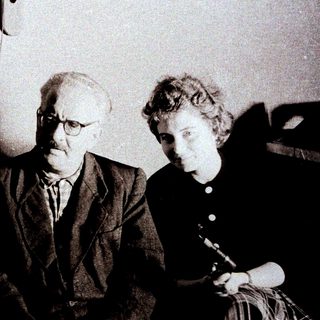 Here's a brief summary of the image: Three people are seated together in a formal setting.