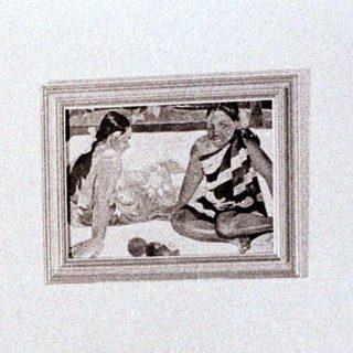 Person writing in bed, with artwork and lamp visible.