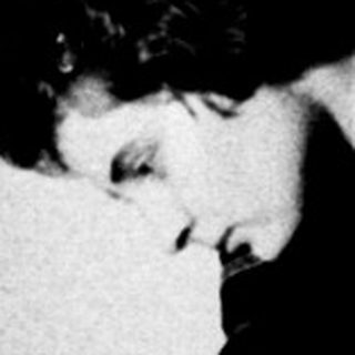 Person reading in a room, lit by a lamp.