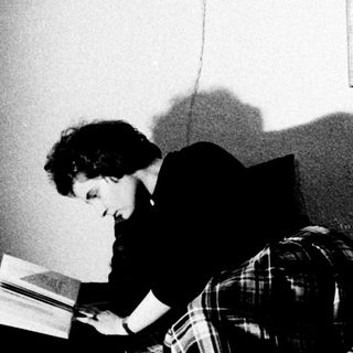 Person reading in a room, lit by a lamp.
