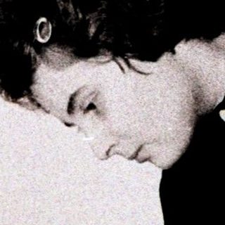 Person reading a book while seated on the floor.