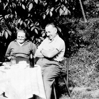 Three people seated at a table outdoors.