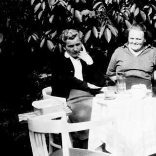 Three people seated at a table outdoors.