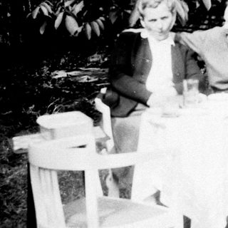 Three people seated at a table outdoors.