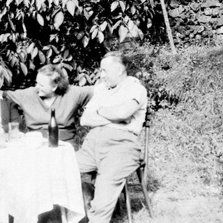 Three people seated at a table outdoors.