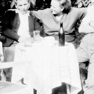 Three people seated at a table outdoors.