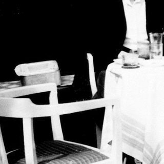 Three people seated at a table, enjoying drinks outdoors.