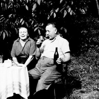 Three people seated at a table, enjoying drinks outdoors.