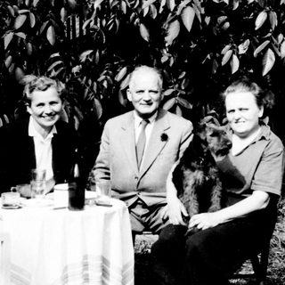 Three people seated at a table outdoors.