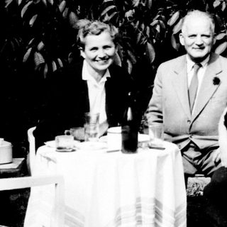Three people seated at a table outdoors.