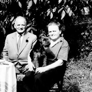 Three people seated at a table outdoors.