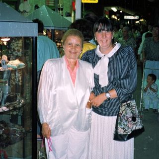 Two women standing indoors, appearing to be in a store.