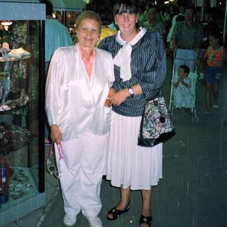 Two women standing indoors, appearing to be in a store.