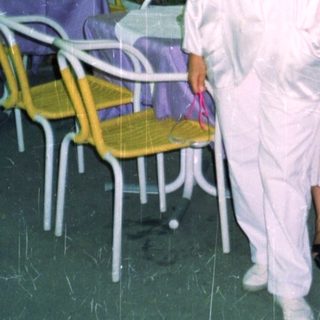 Two women stand outside a store at night.