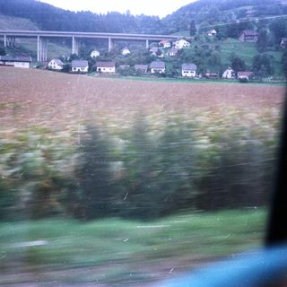 Village with elevated roadway, seen through a window.