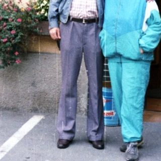 Couple poses outside a building with floral details.