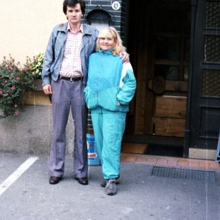 Couple poses outside a building with floral details.
