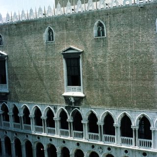 Exterior view of a palace with arches and a tower.