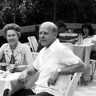 Three people seated at a table outdoors.