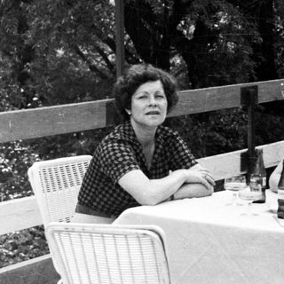 Three people seated at a table outdoors.