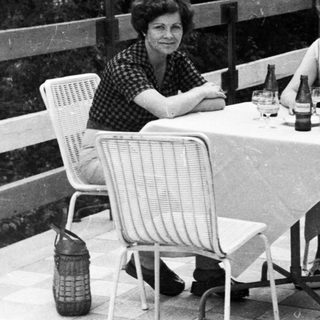 People seated at a table outdoors, enjoying a meal.