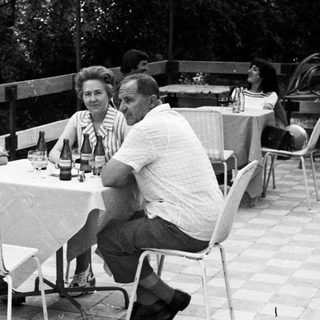 People seated at a table outdoors, enjoying a meal.