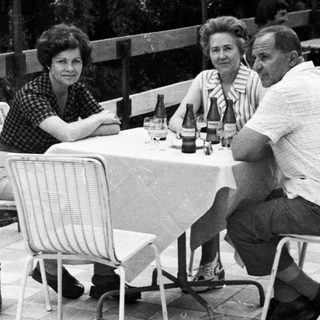 People seated at a table outdoors, enjoying a meal.