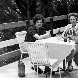 People seated at a table outdoors, enjoying a meal.