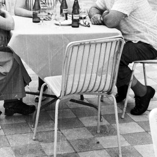 Group of three people seated at a table outdoors.