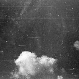 Dark sky with sparse clouds and surface scratches.