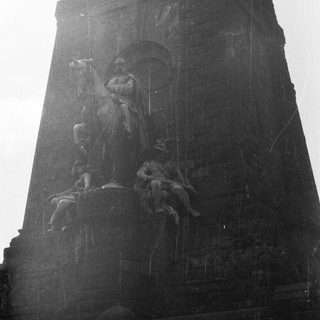 Monumental sculpture depicting a man on horseback and figures.