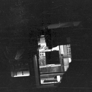 Dark, textured view looking out from a shadowed space.