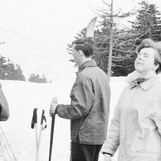 Group of people near a ski lift in a snowy landscape.