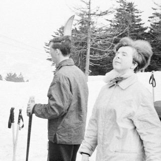 Group of people near a ski lift in a snowy landscape.