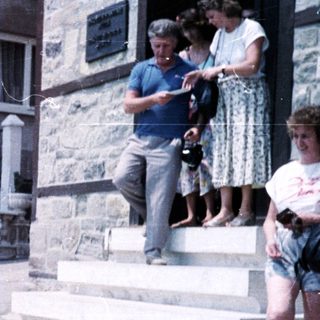 Group of people standing and climbing stone steps.