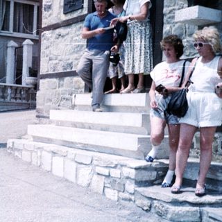 Group of people standing and climbing stone steps.
