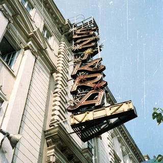 Vintage "SWISS" marquee hangs above a building facade.