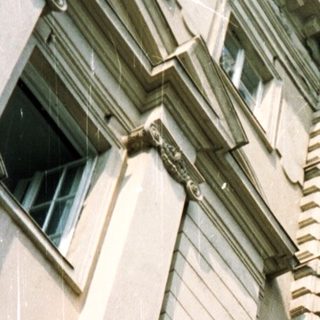 Vintage "SWISS" marquee hangs above a building facade.