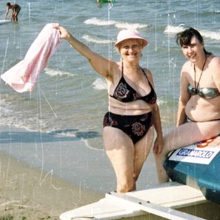 Two women on a lifeguard rescue platform at a beach.