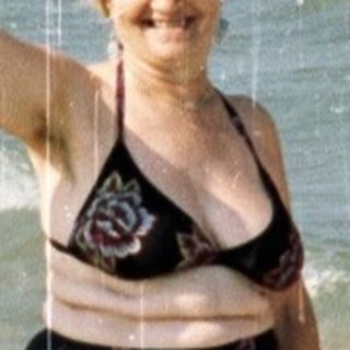 Two women on a lifeguard rescue platform at a beach.
