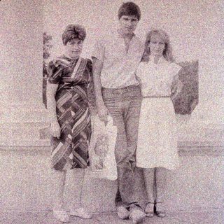 Three children pose for a black and white photograph.