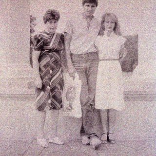 Three children pose for a black and white photograph.