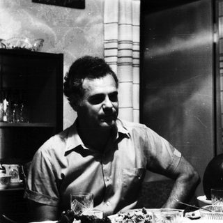 Man seated at a table with glassware and decor.