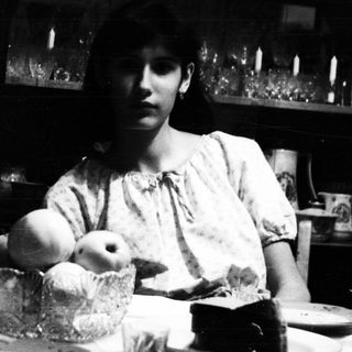 Black and white image of a woman at a table.