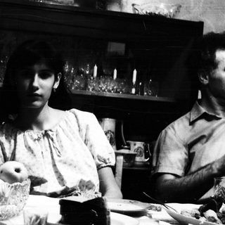 Black and white image of a woman at a table.